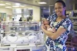 Nurse holding an infant in the NICU.