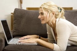 Lady laying on couch with laptop studying