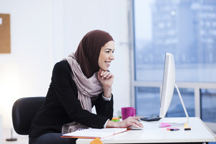 Women sitting behind computer with thumbs up